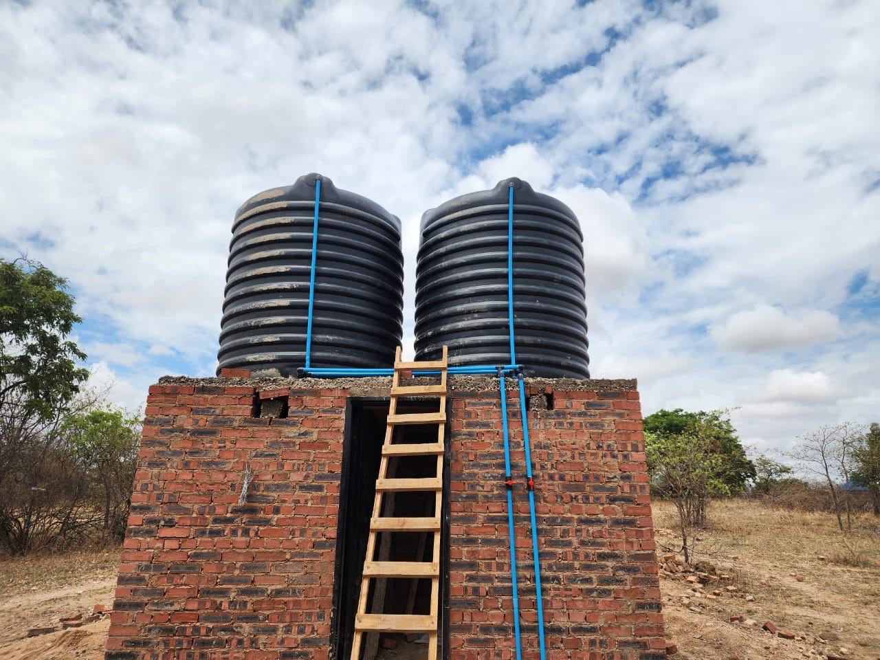 Twin water tank tower with solar-fed pump installation