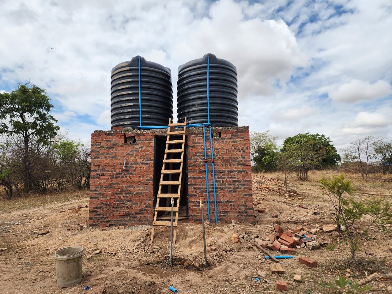Brick water tower with twin tanks fed by solar pump